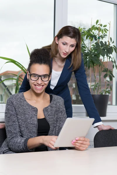 Woman is showing something at a tablet — Stock Photo, Image