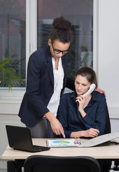 Due donne lavorano in ufficio. Fotografia Stock