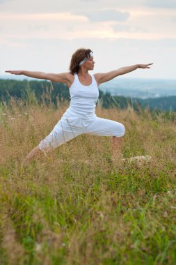 gündoğumu sırasında yoga yaparken kadın