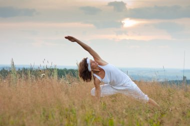 gündoğumu sırasında yoga yaparken kadın