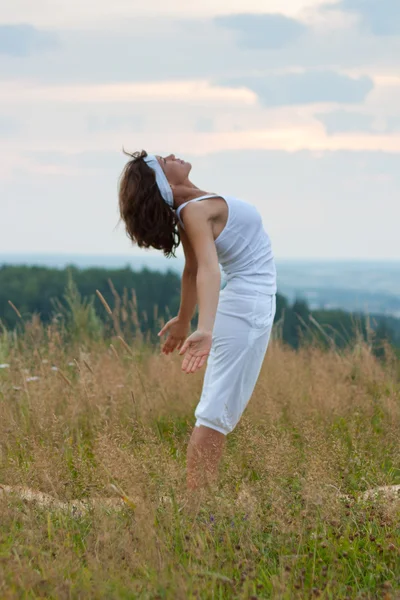 Femme faisant du yoga pendant le lever du soleil — Photo