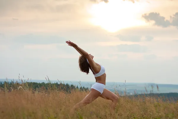 Kvinnan gör yoga under sunrise — Stockfoto