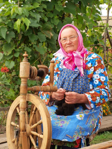 Женщина прядет пряжу — стоковое фото