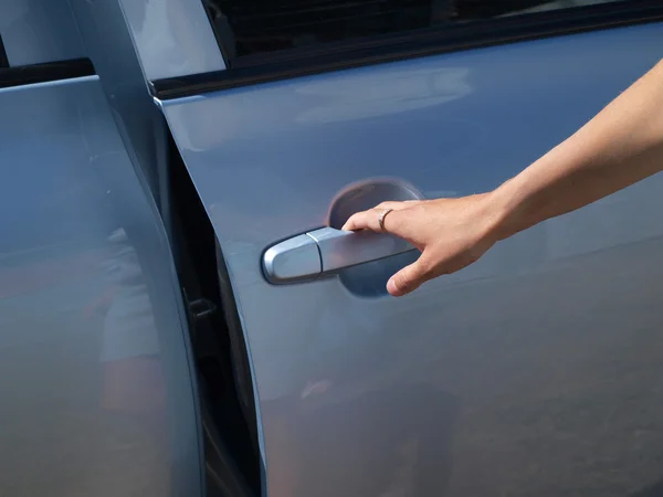 Die Hand, die eine Autotür öffnet Stockbild