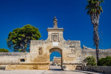 İtalya 'nın küçük, güçlendirilmiş Acaya, Lecce, Salento, Puglia köyü. Büyük taşlarla döşenmiş meydan. Şehre açılan kapı, büyük kemerli ve taş heykeli olan..