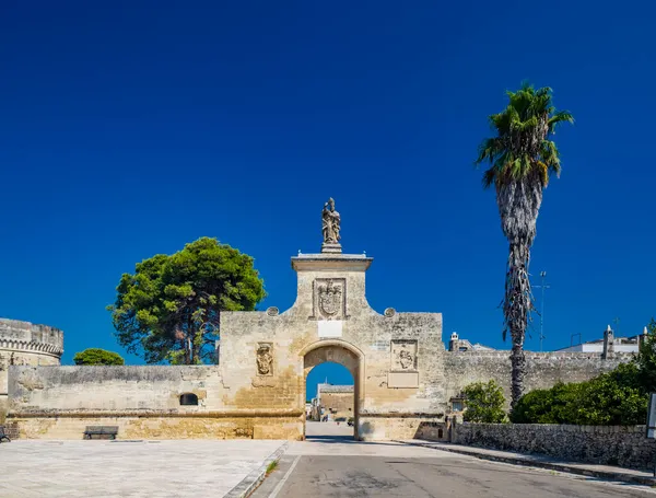 İtalya 'nın küçük, güçlendirilmiş Acaya, Lecce, Salento, Puglia köyü. Büyük taşlarla döşenmiş meydan. Şehre açılan kapı, büyük kemerli ve taş heykeli olan..