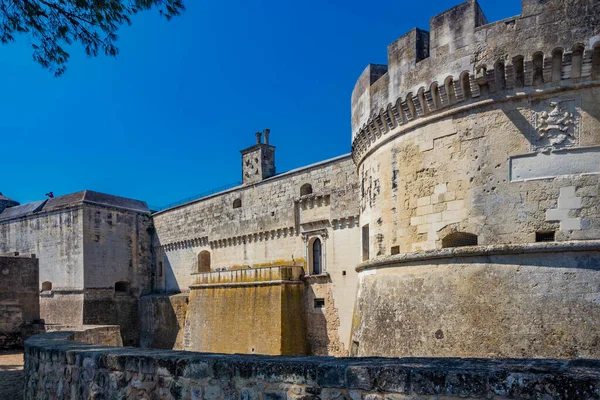 İtalya 'nın küçük, güçlendirilmiş Acaya, Lecce, Salento, Puglia köyü. Büyük taşlarla döşenmiş meydan. Kuleleri ve hendekleri olan antik ortaçağ kalesi..