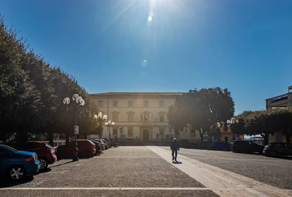 2022年3月13日 トルファ ラツィオ メイン広場と市庁舎がある村を垣間見る 後ろから見た男が道の真ん中を歩いている 太陽フレアとバックライト写真 — ストック写真