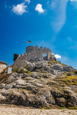 Lazio 'daki küçük Tolfa köyü. Kalenin antik duvarlarının kalıntıları uçurumun tepesinde. Kalenin kalıntıları. Ukrayna bayrağının çekildiği kule dayanışma işareti olarak kullanılıyor..