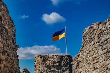 Lazio 'daki küçük Tolfa köyü. Kalenin antik duvarlarının kalıntıları uçurumun tepesinde. Kalenin kalıntıları. Ukrayna bayrağının çekildiği kule dayanışma işareti olarak kullanılıyor..