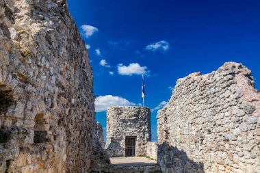 Lazio 'daki küçük Tolfa köyü. Kalenin antik duvarlarının kalıntıları uçurumun tepesinde. Kalenin kalıntıları. Ukrayna bayrağının çekildiği kule dayanışma işareti olarak kullanılıyor..