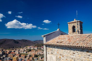 Lazio 'daki küçük Tolfa köyü. Uçurumun tepesindeki Madonna della Rocca Sığınağı. Issız bir merkez ve yukarıdan, kiliseden görünen evlerin çatıları..