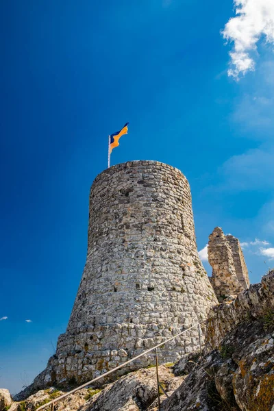 Lazio 'daki küçük Tolfa köyü. Kalenin antik duvarlarının kalıntıları uçurumun tepesinde. Kalenin kalıntıları. Ukrayna bayrağının çekildiği kule dayanışma işareti olarak kullanılıyor..