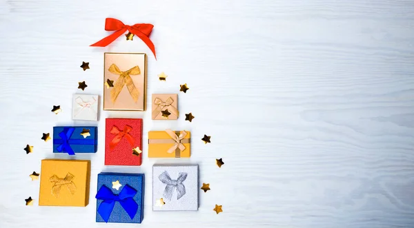 Renkli hediyeler ve hediyelerden yapılmış Noel ağacı. Düz yatıyordu. Tatil kavramı.