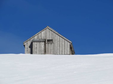 İsviçre dağ kulübeleri kışlık giysiler içinde ve Alpstein dağ sırasının yamaçlarında taze bir kar örtüsüyle Schwaegalp, İsviçre (Schweiz)