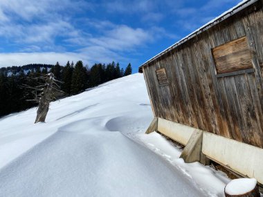 İsviçre dağ kulübeleri kışlık giysiler içinde ve Alpstein dağ sırasının yamaçlarında taze bir kar örtüsüyle Schwaegalp, İsviçre (Schweiz)