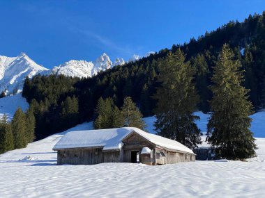 İsviçre dağ kulübeleri kışlık giysiler içinde ve Alpstein dağ sırasının yamaçlarında taze bir kar örtüsüyle Schwaegalp, İsviçre (Schweiz)