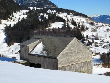İsviçre çayırlarındaki yerli dağ kulübeleri ve ahşap ahırlar taze beyaz kar örtüsüyle kaplıdır, Alt St. Johann - Obertoggenburg, İsviçre (Schweiz)