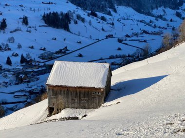 İsviçre çayırlarındaki yerli dağ kulübeleri ve ahşap ahırlar taze beyaz kar örtüsüyle kaplıdır, Alt St. Johann - Obertoggenburg, İsviçre (Schweiz)