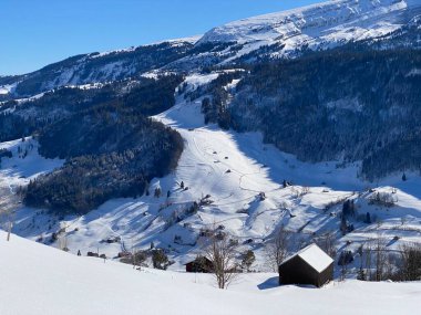 İsviçre çayırlarındaki yerli dağ kulübeleri ve ahşap ahırlar taze beyaz kar örtüsüyle kaplıdır, Alt St. Johann - Obertoggenburg, İsviçre (Schweiz)