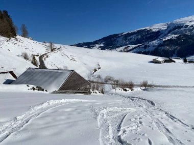 İsviçre çayırlarındaki yerli dağ kulübeleri ve ahşap ahırlar taze beyaz kar örtüsüyle kaplıdır, Alt St. Johann - Obertoggenburg, İsviçre (Schweiz)