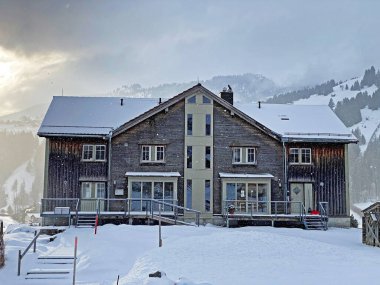 Geleneksel İsviçre mimarisi ve beyaz kar örtüsünün kış atmosferinde ahşap alp evler, Unterwasser - Obertoggenburg, İsviçre (Schweiz)