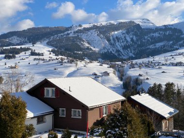 Geleneksel İsviçre mimarisi ve beyaz kar örtüsünün kış atmosferinde ahşap alp evler, Unterwasser - Obertoggenburg, İsviçre (Schweiz)