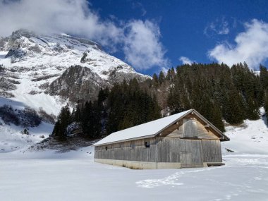 Yerli alp kulübeleri ve İsviçre çayırlarındaki ahşap ahırlar taze beyaz kar örtüsüyle kaplıdır, Unterwasser - Obertoggenburg, İsviçre (Schweiz)
