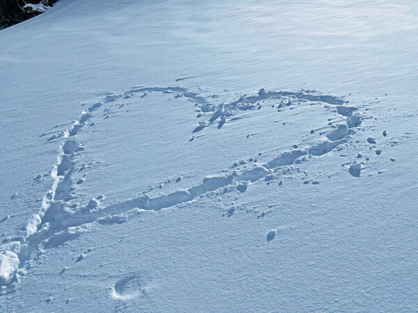 Icy snow heart - traces in fresh alpine snow in the shape of a heart on the slopes of the Alpstein mountain range, Unterwasser - Canton of St. Gallen, Switzerland (Schweiz)
