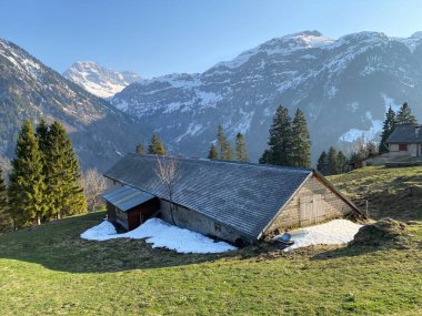Dağ kulübeleri (chalets) veya çiftlik evleri ve Klontal Alp Vadisi 'ndeki eski ahşap sığır evleri (veya Kloental) ve Klontalersee Glarus Kantonu (Kloentalersee) - İsviçre / Schweiz Kantonu
