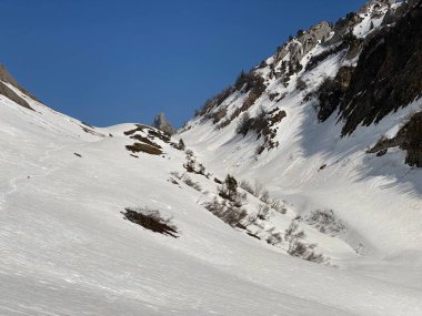 Eriyen kar örtüsü ve Alp Vadisi 'ndeki erken bahar atmosferi Lochboden ve Glarus Alp Dağları' ndaki Sulzbach deresi vadisinde - Glarus Kantonu, İsviçre / Schweiz