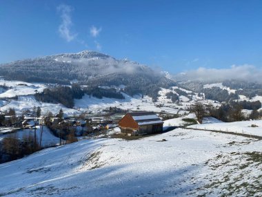 İsviçre çayırlarındaki yerli dağ kulübeleri ve ahşap ahırlar taze beyaz kar örtüsüyle kaplıdır, Nesslau - Obertoggenburg, İsviçre (Schweiz)