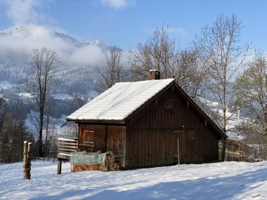 İsviçre çayırlarındaki yerli dağ kulübeleri ve ahşap ahırlar taze beyaz kar örtüsüyle kaplıdır, Nesslau - Obertoggenburg, İsviçre (Schweiz)