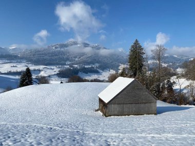 İsviçre çayırlarındaki yerli dağ kulübeleri ve ahşap ahırlar taze beyaz kar örtüsüyle kaplıdır, Nesslau - Obertoggenburg, İsviçre (Schweiz)