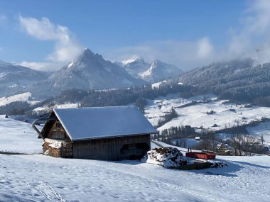 İsviçre çayırlarındaki yerli dağ kulübeleri ve ahşap ahırlar taze beyaz kar örtüsüyle kaplıdır, Nesslau - Obertoggenburg, İsviçre (Schweiz)