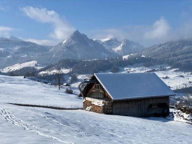 İsviçre çayırlarındaki yerli dağ kulübeleri ve ahşap ahırlar taze beyaz kar örtüsüyle kaplıdır, Nesslau - Obertoggenburg, İsviçre (Schweiz)