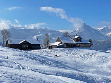 İsviçre çayırlarındaki yerli dağ kulübeleri ve ahşap ahırlar taze beyaz kar örtüsüyle kaplıdır, Nesslau - Obertoggenburg, İsviçre (Schweiz)