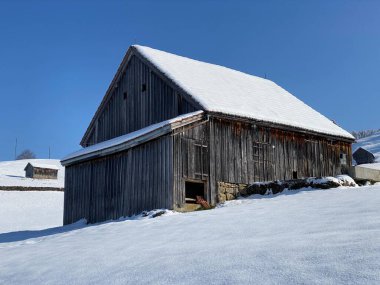 İsviçre çayırlarındaki yerli dağ kulübeleri ve ahşap ahırlar taze beyaz kar örtüsüyle kaplıdır, Nesslau - Obertoggenburg, İsviçre (Schweiz)