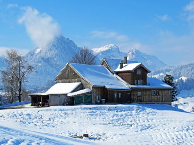 İsviçre çayırlarındaki yerli dağ kulübeleri ve ahşap ahırlar taze beyaz kar örtüsüyle kaplıdır, Nesslau - Obertoggenburg, İsviçre (Schweiz)