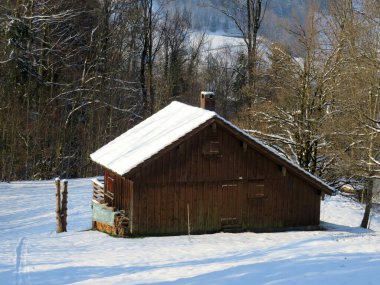 İsviçre çayırlarındaki yerli dağ kulübeleri ve ahşap ahırlar taze beyaz kar örtüsüyle kaplıdır, Nesslau - Obertoggenburg, İsviçre (Schweiz)