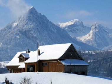 İsviçre çayırlarındaki yerli dağ kulübeleri ve ahşap ahırlar taze beyaz kar örtüsüyle kaplıdır, Nesslau - Obertoggenburg, İsviçre (Schweiz)