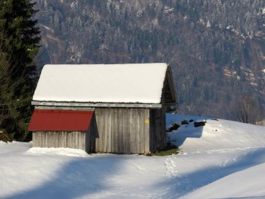 İsviçre çayırlarındaki yerli dağ kulübeleri ve ahşap ahırlar taze beyaz kar örtüsüyle kaplıdır, Nesslau - Obertoggenburg, İsviçre (Schweiz)