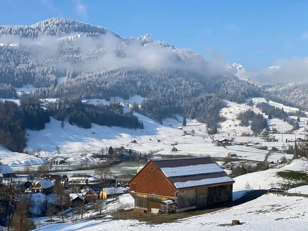 İsviçre çayırlarındaki yerli dağ kulübeleri ve ahşap ahırlar taze beyaz kar örtüsüyle kaplıdır, Nesslau - Obertoggenburg, İsviçre (Schweiz)