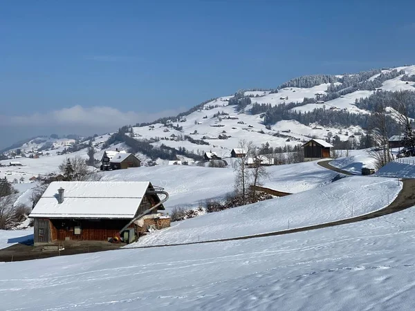 İsviçre çayırlarındaki yerli dağ kulübeleri ve ahşap ahırlar taze beyaz kar örtüsüyle kaplıdır, Nesslau - Obertoggenburg, İsviçre (Schweiz)
