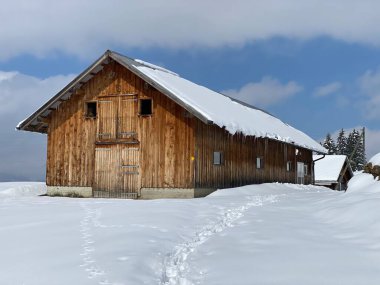 İsviçre çayırlarındaki yerli dağ kulübeleri ve ahşap ahırlar taze beyaz kar örtüsüyle kaplıdır, Nesslau - Obertoggenburg, İsviçre (Schweiz)