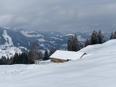 İsviçre çayırlarındaki yerli dağ kulübeleri ve ahşap ahırlar taze beyaz kar örtüsüyle kaplıdır, Nesslau - Obertoggenburg, İsviçre (Schweiz)