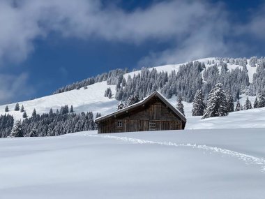 İsviçre çayırlarındaki yerli dağ kulübeleri ve ahşap ahırlar taze beyaz kar örtüsüyle kaplıdır, Nesslau - Obertoggenburg, İsviçre (Schweiz)