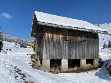 İsviçre çayırlarındaki yerli dağ kulübeleri ve ahşap ahırlar taze beyaz kar örtüsüyle kaplıdır, Nesslau - Obertoggenburg, İsviçre (Schweiz)