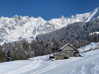 İsviçre çayırlarındaki yerli dağ kulübeleri ve ahşap ahırlar taze beyaz kar örtüsüyle kaplıdır, Nesslau - Obertoggenburg, İsviçre (Schweiz)