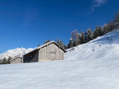 İsviçre çayırlarındaki yerli dağ kulübeleri ve ahşap ahırlar taze beyaz kar örtüsüyle kaplıdır, Nesslau - Obertoggenburg, İsviçre (Schweiz)